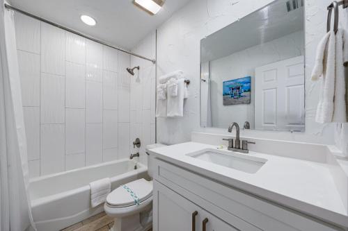 a white bathroom with a sink and a toilet at Crescent Beach Villas By Beachside Management in Siesta Key