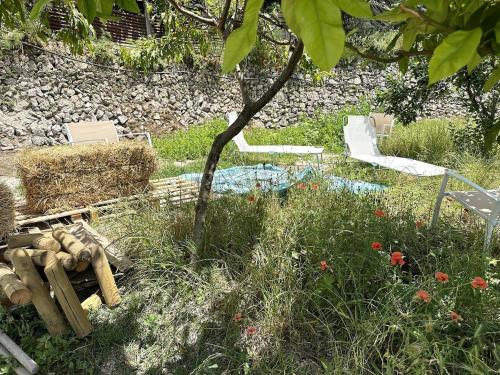 a garden with hay and a chair and a tree at Casa Sangineto - Minori - Costa Amalfitana- A Paradise in the countryside in Minori