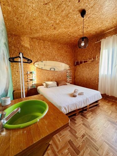 a bathroom with a green sink and a bed at Eco Hostel - Tribo da Praia in Ferrel