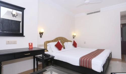 a hotel room with a bed and a desk at Hotel Park International Varkala in Varkala