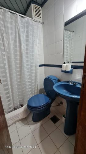a bathroom with a blue toilet and a sink at Avenida Argentina in Monte Hermoso