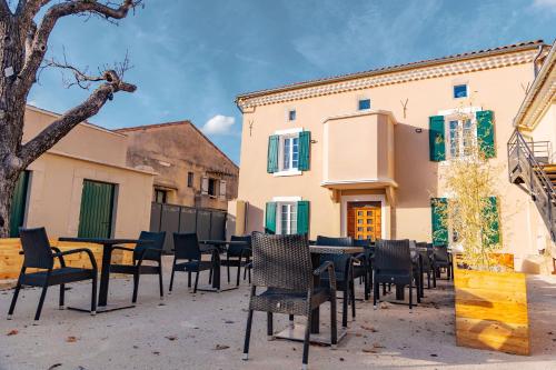 un groupe de tables et de chaises devant un bâtiment dans l'établissement Le gîte du Haut de la Sousto, à Rasteau