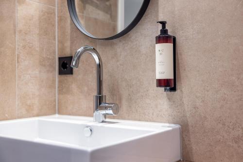 a bathroom sink with a bottle of wine on the wall at Broeck Oudewater in Oudewater
