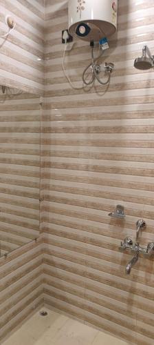 a bathroom with a shower with wooden walls at Digaru Air House in Digru