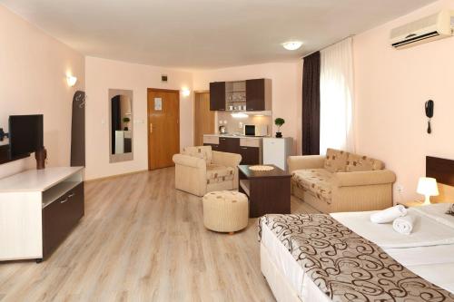 a hotel room with a bed and a living room at Apart Hotel Vechna R in Sunny Beach