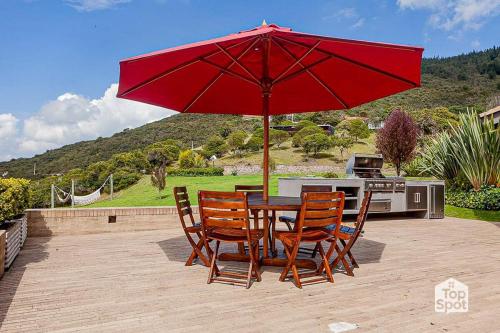 a table and chairs under a red umbrella on a patio at TopSpot with Super View in the Guasca Mountains in Cundinamarca