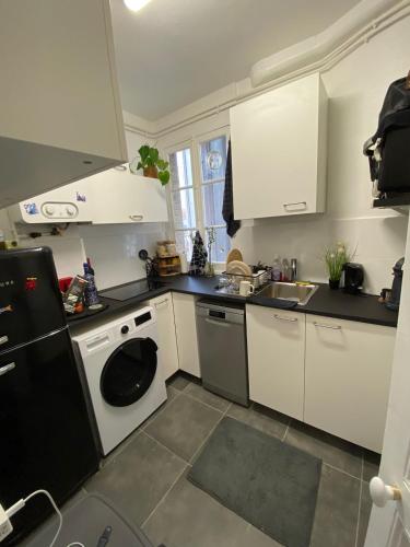 une cuisine avec un lave-linge et un lave-vaisselle dans l'établissement Beautiful Parisian apartment, 15 min from Châtelet, à Clichy