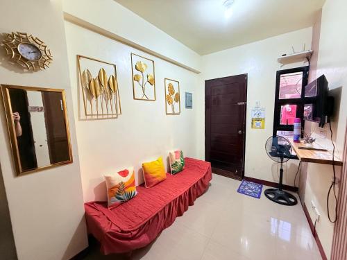 a room with a red couch with colorful pillows on it at budget transient house near sm Lucena 6pax in Lucena