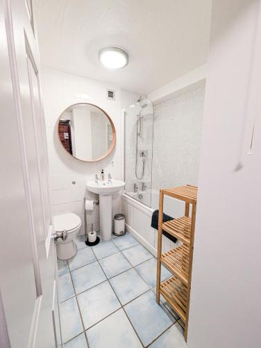 a bathroom with a sink and a toilet and a mirror at South Fistral View Apartment in Newquay