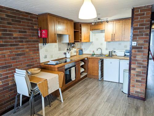 eine Küche mit Holzschränken und einer Ziegelwand in der Unterkunft South Fistral View Apartment in Newquay