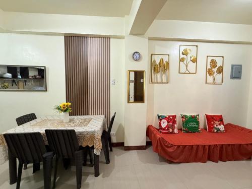 a dining room with a table and a bed with pillows at budget transient house near sm Lucena 6pax in Lucena