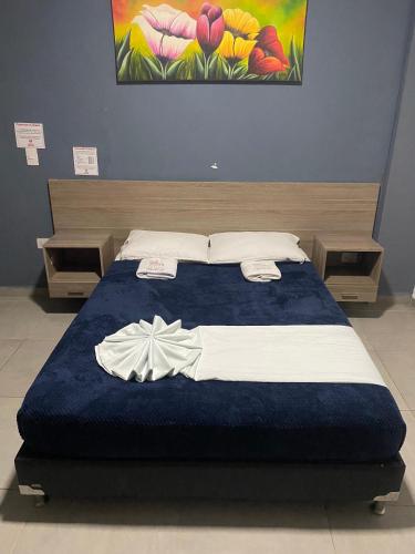 a bedroom with a bed with a blue blanket at Hotel America 52 in Rionegro