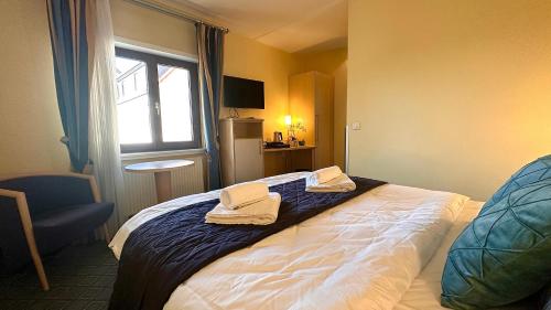 a hotel room with a bed with towels on it at AR Boutique Hotel Mannheim in Mannheim