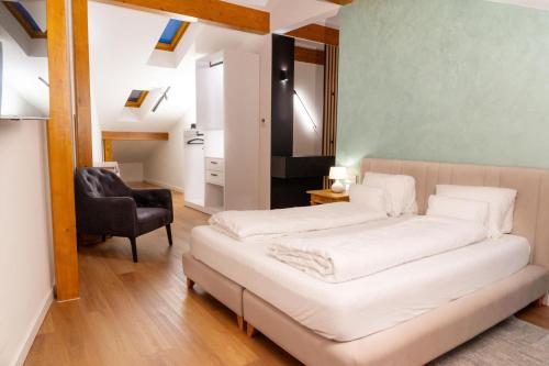 a bedroom with a bed and a chair at Boutique Hotel OchSen Self-Check-In in Bad Ragaz