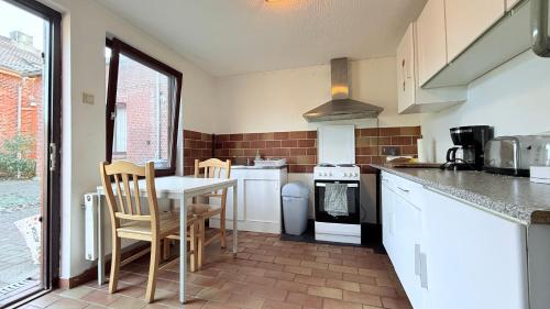 a kitchen with a table and a stove top oven at Monteurhaus in Itzehoe ruhige Lage, Küche & Parkplatz inklusive in Itzehoe