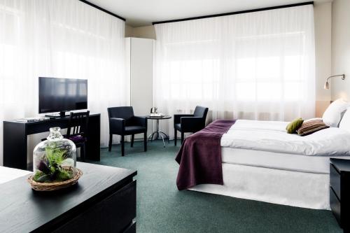 a bedroom with a bed and a desk with a television at 22 Hill Hotel in Reykjavík