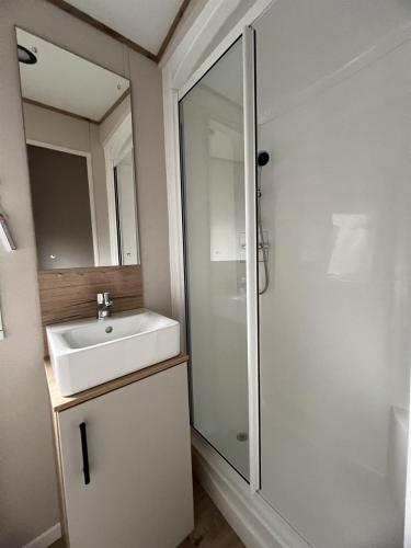 a white bathroom with a sink and a shower at Caravan on Fantastic site in Dunbar