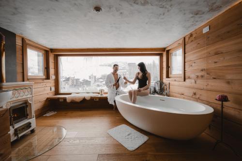 a man and a woman sitting in a bath tub in a bathroom at Sertorelli Sporthotel in Breuil-Cervinia