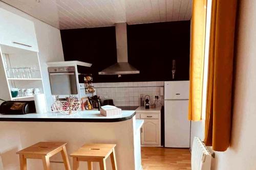 - une cuisine avec un comptoir et deux tabourets dans l'établissement Le Libergier, à Reims