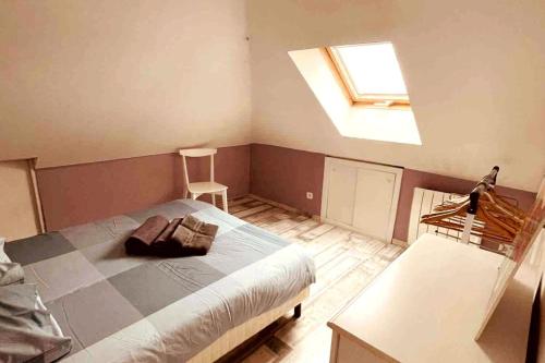 une chambre avec un grand lit avec une lucarne dans l'établissement Le Libergier, à Reims