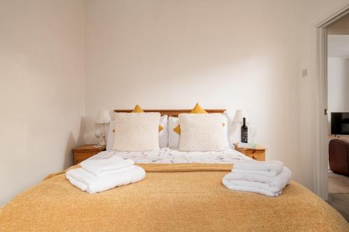 a bedroom with a bed with white towels on it at Horseshoe Cottage in Bridlington