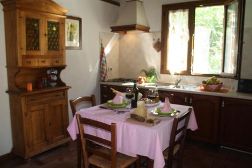 a kitchen with a table with a pink table cloth at Agriturismo Il Giardino in Sansepolcro