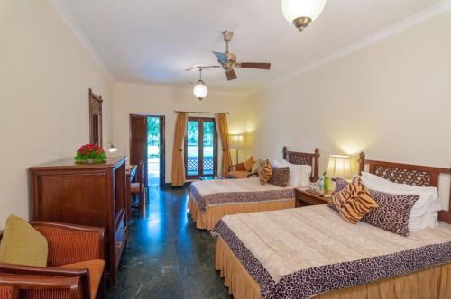 a hotel room with two beds and a ceiling fan at Sawai Madhopur Lodge - IHCL SeleQtions in Sawāi Mādhopur
