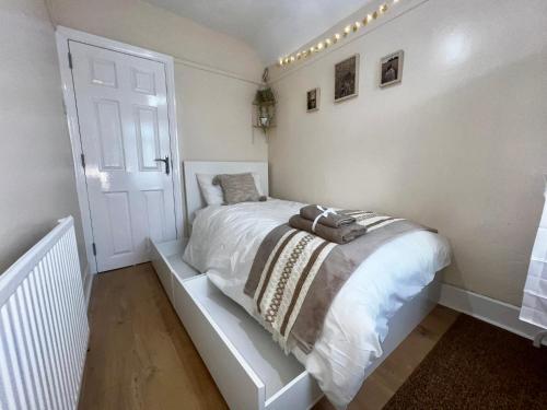 a white bedroom with a bed in a room at Luxurious Cozy London Holiday Home in Cranford