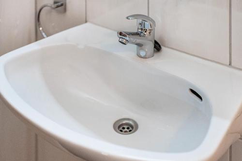 a white sink in a bathroom with a faucet at Fuchsmichelhof 2 in Seebach