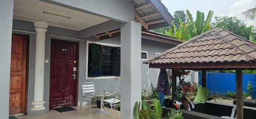 a house with a porch and a table and chairs at MRI Residence - Homestay in Sg Buloh with Swimming Pool - No Pork&Alcohol Allowed in Bandar Puncak Alam