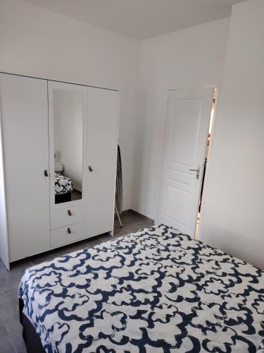 - une chambre avec un lit et une armoire blanche dans l'établissement Joli appartement proche transport, à Vénissieux