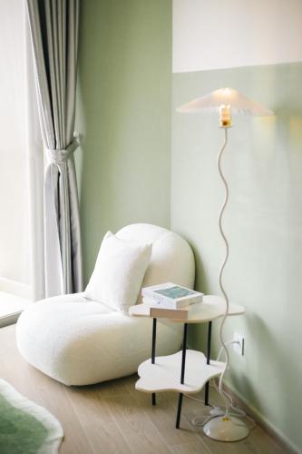 a bedroom with a bed and a table with a lamp at Erica's House - Oceanview The Sóng Apartment Vũng Tàu Nghỉ Dưỡng Biển Cao Cấp 5 Sao - The Song Vung Tau Condotel 5 Star Beach View Apartment in Vung Tau