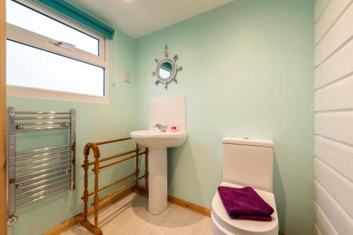 a bathroom with a sink and a toilet at WestHill Beach Chalet, Riviere Towans in Hayle