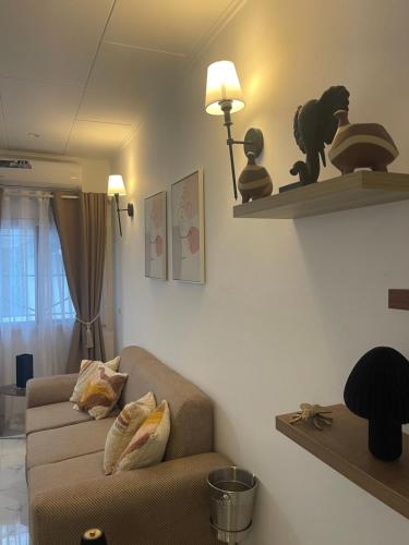 a living room with a couch and shelves on the wall at Les apparts d Agathe in Brazzaville