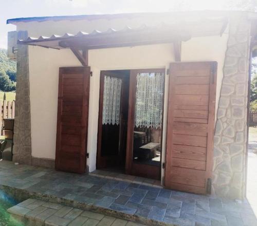 a house with two wooden doors and a porch at La Casetta della valle di Civita in Bagnoregio