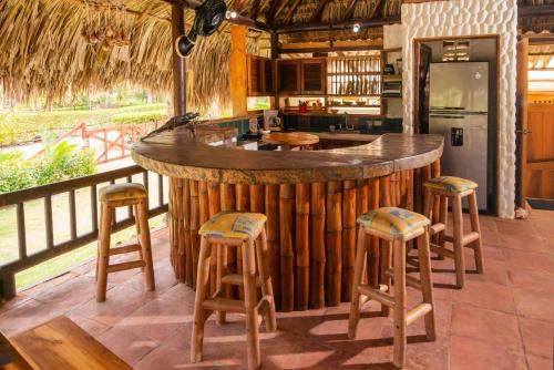 a bar in a kitchen with stools around it at Cabaña San Miguel in Moñitos