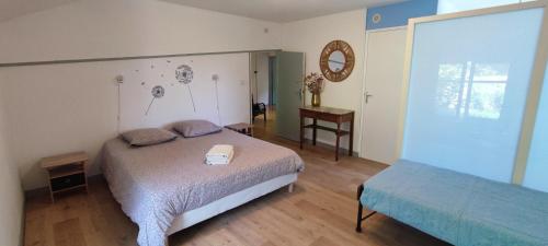 - une chambre avec un lit et une table avec un miroir dans l'établissement Les chambres d'hôtes de La Bastide du puech, à Cransac