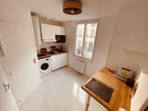 une petite cuisine blanche avec une table et une fenêtre dans l'établissement Paradis secret - 363, à Rouen