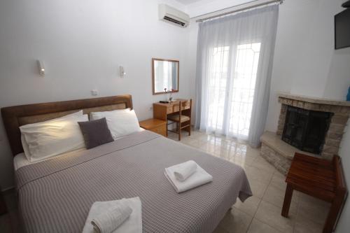 a bedroom with a large bed with a fireplace at PortoDream Studios & Apartments in Neos Marmaras