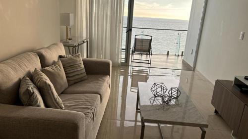 a living room with a couch and a glass table at Apartment In Camino Al Mar with Amazing View of the Ocean, Beach and Swimming Pool, 2 Rooms in Mazatlán