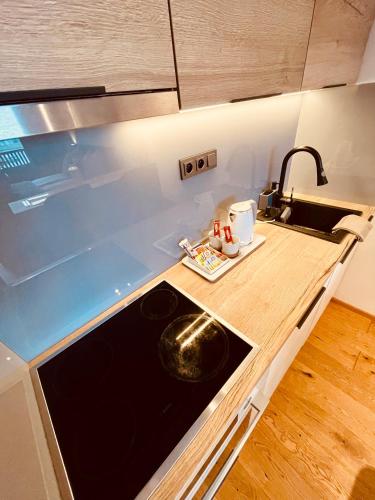 a small kitchen with a sink and a stove at Tee House - Forest Apartment Čeladná in Čeladná