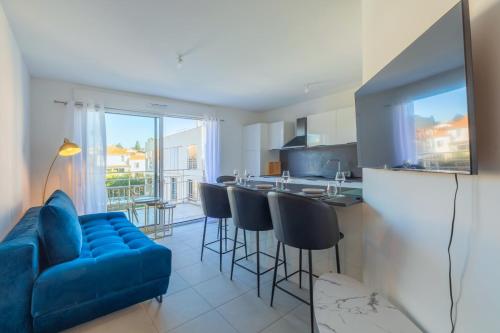 un salon avec un canapé bleu et une cuisine dans l'établissement Appartement Azzuro - Welkeys, à Antibes