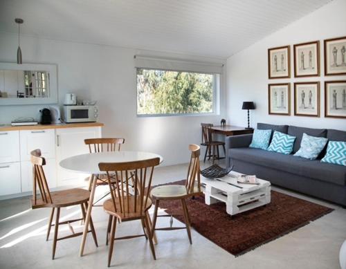 a living room with a couch and a table and chairs at Casal do Frade in Sesimbra