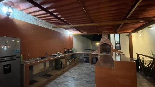 a large kitchen with a counter and a fireplace at Habitacion con piscina-jacuzzi-lavadora disponible in Juan de Acosta