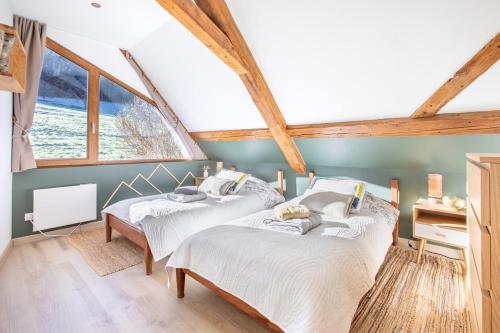 deux lits dans une chambre avec une fenêtre dans l'établissement La Grande Vallée - Vue exceptionnelle, à Orbey