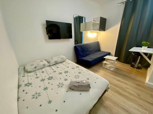 une chambre avec un lit et une chaise bleue dans l'établissement Studio Convention Porte de Versailles, à Paris