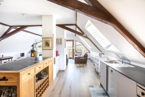 d'une cuisine mansardée avec des murs blancs et des poutres en bois. dans l'établissement La Grande Vallée - Vue exceptionnelle, à Orbey