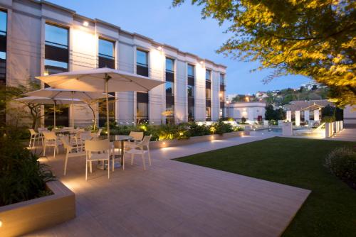 a patio with a table and chairs and an umbrella at Holiday Inn Express - Concepcion by IHG in Concepción
