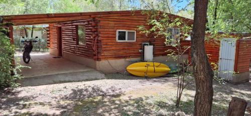 a log cabin with a surfboard in front of it at Cabaña Trapiche San Luis in Trapiche