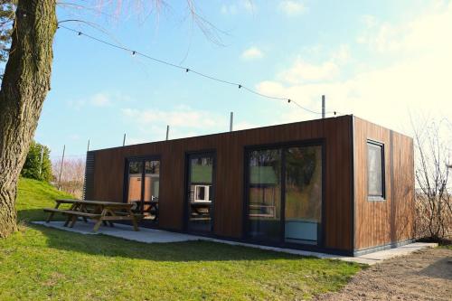 a small cabin with a picnic table and a tree at The family cabin - Quercus in Evergem